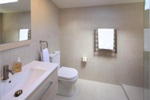ein Badezimmer mit einer weißen Toilette und einem Waschbecken in der Unterkunft Noll View - Stay Waiheke in Oneroa + 17 Fotos