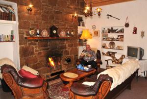 einem Mann, der in einem Wohnzimmer mit Kamin sitzt in der Unterkunft The Olde Castle B&B in Renvyle