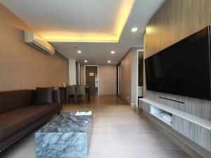 a living room with a couch and a large flat screen tv at 18 Residence in Bangkok