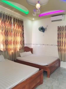 two beds in a room with curtains and avertisement for at Lộc An Lý Sơn Motel in Ly Son