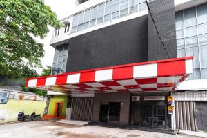 een rood-wit tankstation voor een gebouw bij Glamour Hotel and Spa in Medan