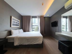 a bedroom with a bed and a large window at 18 Residence in Bangkok