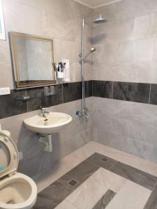 a bathroom with a sink and a toilet and a mirror at Yue Ya Wan Homestay in Checheng