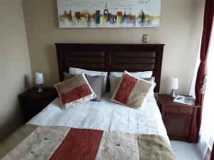 塔尔卡瓦诺MaranathaAparthotel的一间卧室，配有一张大床和两个枕头