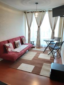 a living room with a red couch and a table at MaranathaAparthotel in Talcahuano