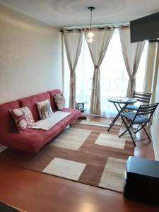 sala de estar con sofá rojo y mesa en MaranathaAparthotel en Talcahuano