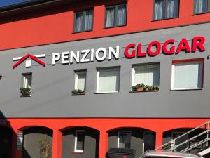 a red and white building with a sign on it at Penzion Glogar in Frýdek-Místek