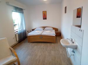 a bedroom with a bed and a sink at Penzion u Náhonu in Město Touškov