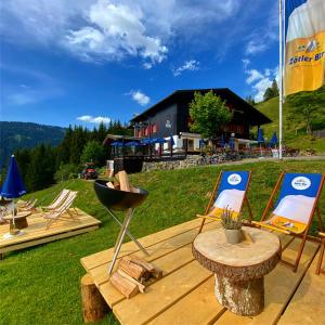 a patio with two chairs and a table and a building at Boden Balderschwang in Balderschwang