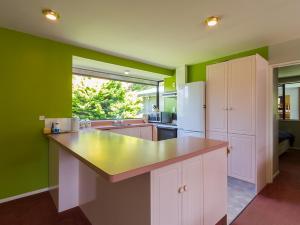 cocina con paredes verdes y nevera blanca en Mill House - Wanaka Holiday Home, en Wanaka 16 fotos más