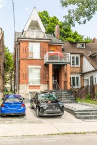 two cars parked in front of a brick house at NB Urban Luxury Suites in Toronto