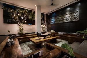 a room with a bench and a table and plants at PATIO Hotel & Urban Resort in Phnom Penh