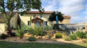 a house with a garden in front of it at The Walnut Tree Gite in Le Dorat
