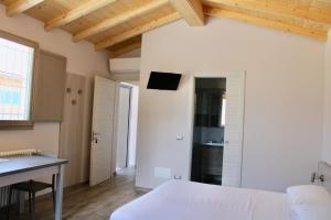 a bedroom with a white bed and a desk at Agriturismo Ravaglia Grande in Castel Guelfo di Bologna