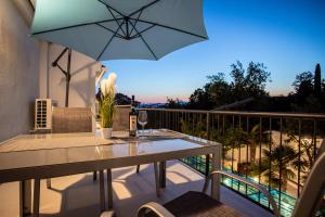 a patio with a table and an umbrella on a balcony at Apartments San Leopoldo in Crikvenica