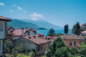 a group of buildings with a lake in the background at Villa Amfora in Ohrid