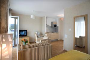 a living room with a couch and a dining room at Domitys Les Clés d'Or in Orthez +6 photos