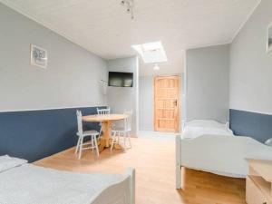 a room with two beds and a table and a table at Pokoje gościnne Bartek in Białogóra
