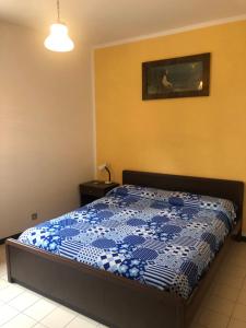 ein Schlafzimmer mit einem Bett mit einer blau-weißen Bettdecke in der Unterkunft Caffè Martini in Arsiero