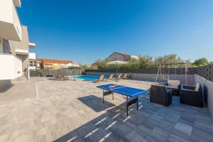 une terrasse avec une table de ping-pong et une table de ping-pong dans l'établissement VILLA SOFIJA, à Zaton