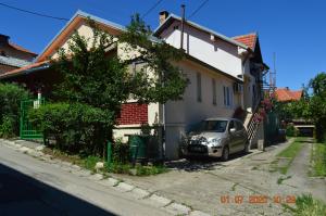 une voiture garée devant une maison dans l'établissement Apartmani Perovic, à Sokobanja