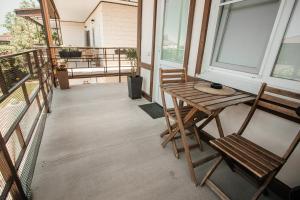a porch with a wooden table and chairs on a balcony at Sovenok Apart-Hotel in Yeysk