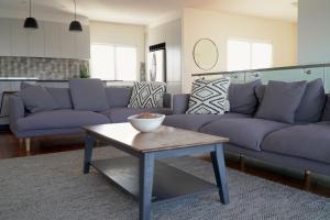 a living room with purple couches and a table at Caves Coastal Bar & Bungalows in Caves Beach