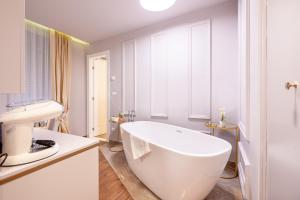 een badkamer met een wit bad en een wastafel bij Luxury rooms Kadena in Zadar