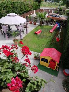 a toy play house with a slide in a backyard at Studio Eleni in Néa Agathoúpolis