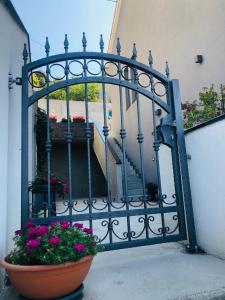 a gate with flowers in a pot next to a staircase at Apartments Slavica in Šibenik
