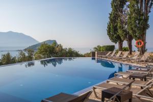 een zwembad met ligstoelen en een resort bij Avala Resort & Villas in Budva