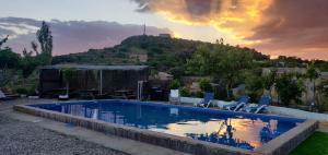 a swimming pool with two chairs and a hill at Casa Plana Calasanz in Calasanz