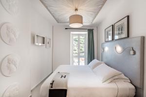 a white bedroom with a bed and a window at La Torretta Lodge in Manarola