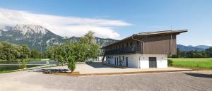ein Gebäude mit einem Berg im Hintergrund in der Unterkunft Water, Ski & Mountain Lodge in Kiefersfelden
