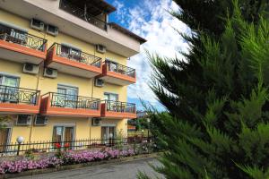 a yellow building with balconies and flowers on it at GOLDEN SUN STUDIOS in Kallithea Halkidikis