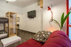 Una sala de estar con un sofá rojo y un televisor de pantalla plana. en Apartma N'Poznam, en Liubliana