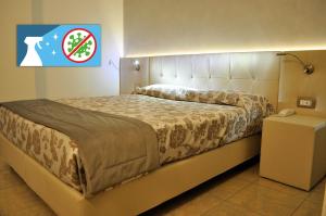 ein großes Bett in einem Zimmer mit einem Schild an der Wand in der Unterkunft Hotel Garibaldi in Mestre