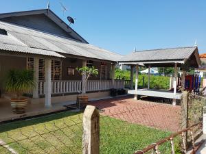 a house with a fence in front of a yard at SRI IMAN HOMESTAY KUALA TERENGGANU in Kuala Terengganu