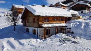 a wooden house covered in snow in the snow at Alpenchalet Garfrescha in Sankt Gallenkirch
