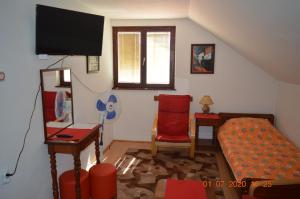 - un salon avec un lit et une télévision dans l'établissement Apartmani Perovic, à Sokobanja