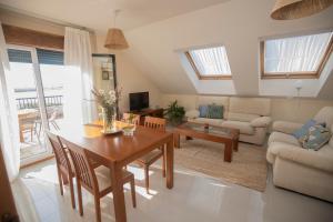 a living room with a table and a couch at Atico con vistas a la Lanzada in A Lanzada