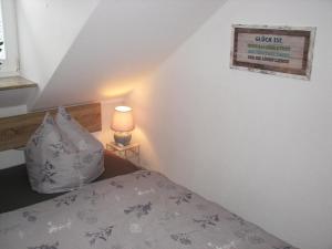 ein Schlafzimmer mit einem Bett mit einem Kissen und einer Lampe in der Unterkunft Ferienzimmer Zentrum in Bad Schandau