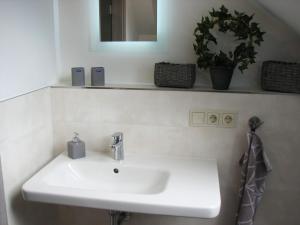 ein Badezimmer mit einem weißen Waschbecken und einem Spiegel in der Unterkunft Ferienzimmer Zentrum in Bad Schandau