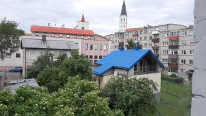 a blue roof on a building in a city at Jaukūs apartamentai-studija, centre in Šiauliai