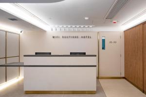 an office lobby with a reception counter and a wall behind it at Wifi Boutique Hotel in Hong Kong