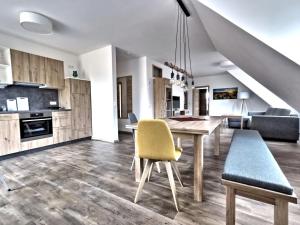 a kitchen with a wooden table and yellow chairs at Ferienwohnungen Fewo Landglück in Herrieden