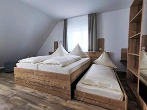 2 camas individuales en una habitación con ventana en Ferienwohnungen Fewo Landglück, en Herrieden