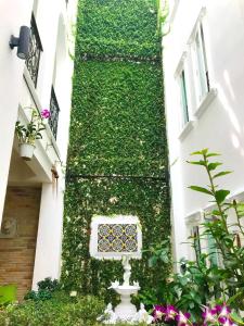 a ivy covered building with a column with a window at Casa Blanca Boutique Hotel - SHA Plus in Phuket Town