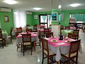 a restaurant with pink tables and chairs and green walls at Verde Mare in Silvi Marina