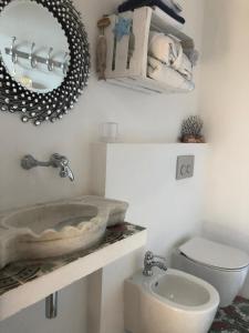 a bathroom with a sink and a toilet and a mirror at Le Stanze sul Mare in Portoferraio
